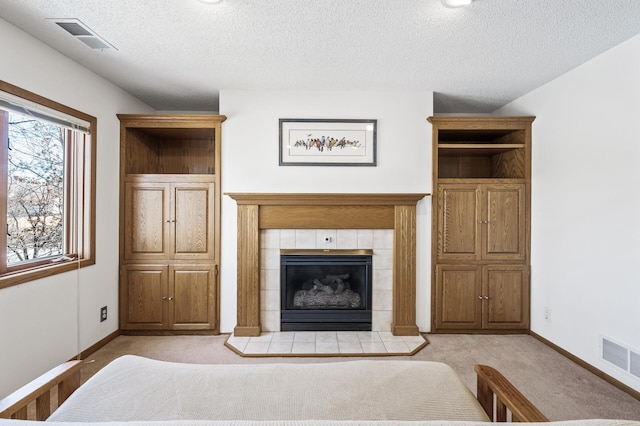 unfurnished living room featuring visible vents, a fireplace, light carpet, and baseboards