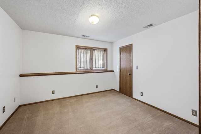 empty room with baseboards, a textured ceiling, visible vents, and carpet flooring