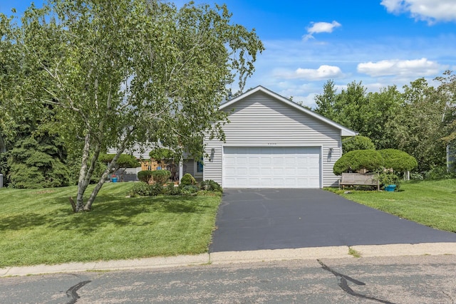 view of front of house featuring a garage, driveway, and a front lawn