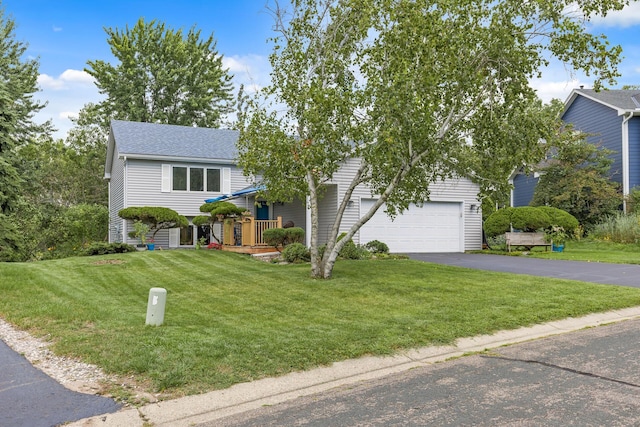 view of front of property with a garage, roof with shingles, driveway, and a front lawn