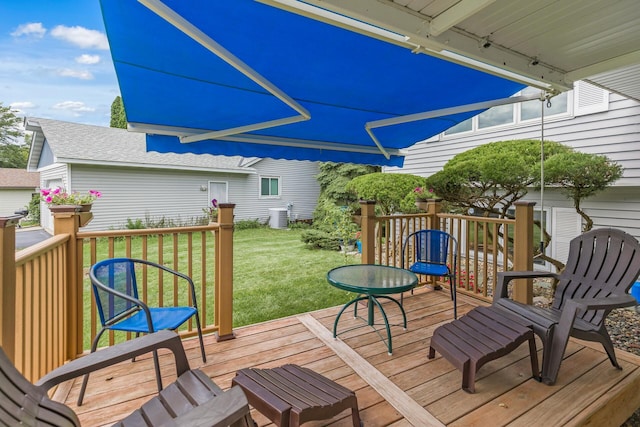 wooden deck featuring central air condition unit and a yard