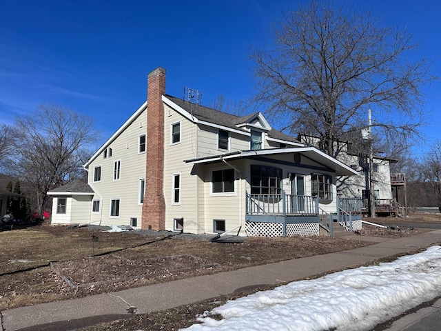 view of front of property featuring covered porch and a chimney