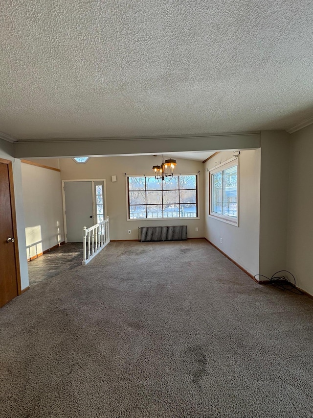 unfurnished room with radiator, carpet, a textured ceiling, and a notable chandelier