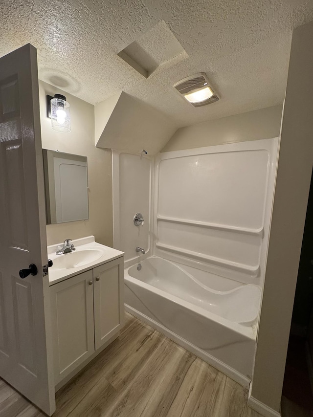 full bathroom featuring shower / bath combination, a textured ceiling, wood finished floors, and vanity