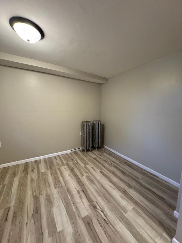 unfurnished room with baseboards and wood finished floors