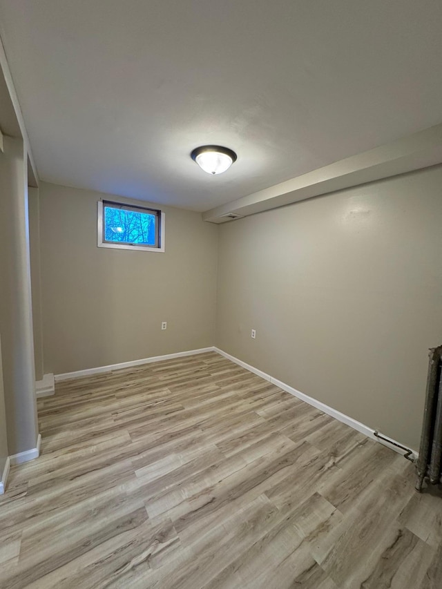 below grade area featuring light wood-style floors and baseboards