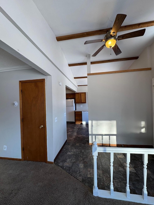 unfurnished room featuring a ceiling fan, dark colored carpet, vaulted ceiling with beams, and baseboards