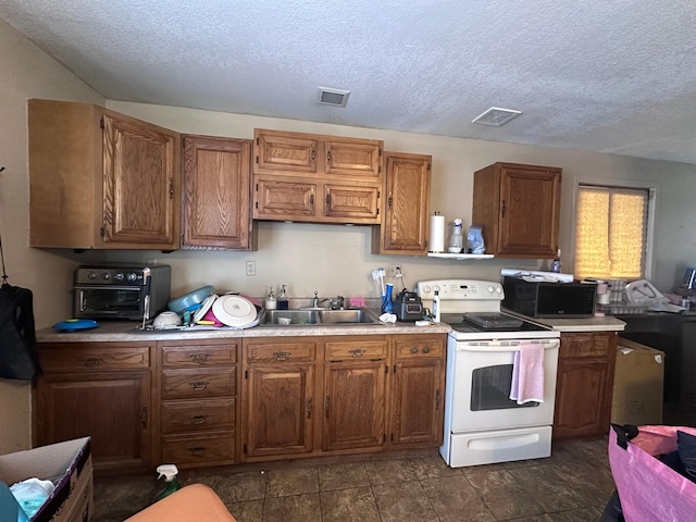 kitchen featuring white electric stove, black microwave, brown cabinetry, and a sink