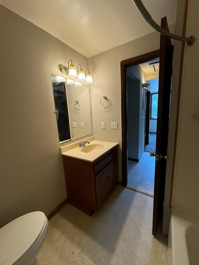 bathroom with toilet, tile patterned flooring, vanity, and baseboards