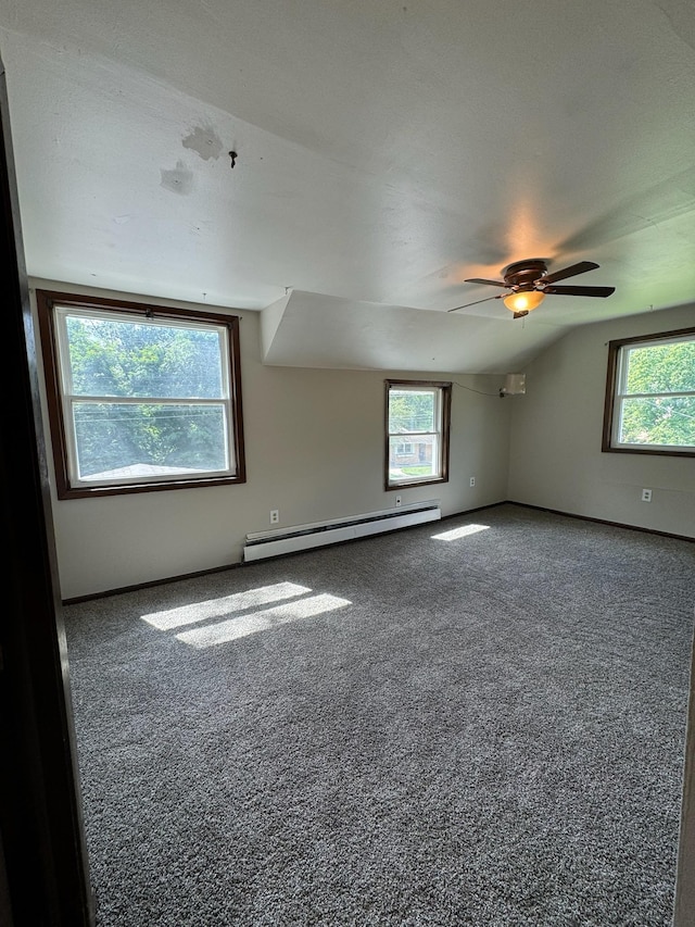 empty room featuring carpet, vaulted ceiling, baseboard heating, and ceiling fan