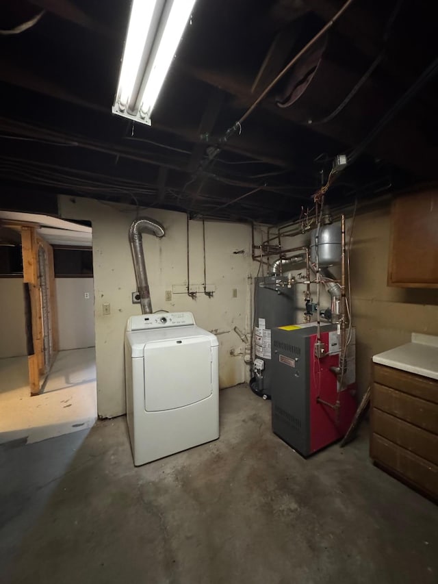 unfinished basement with a heating unit, washer / clothes dryer, and gas water heater