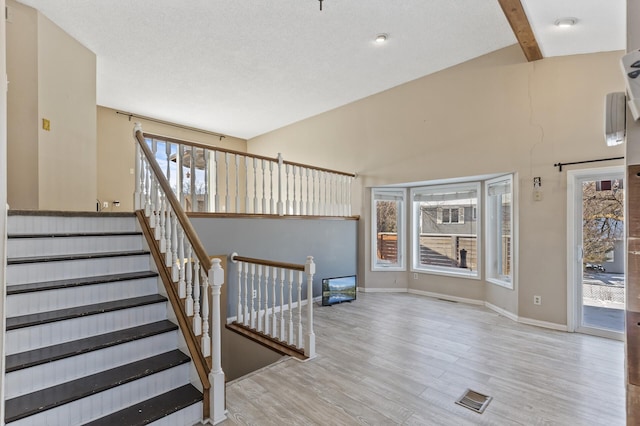 stairs featuring beam ceiling, wood finished floors, visible vents, and baseboards