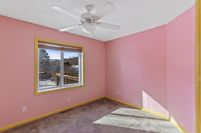 carpeted empty room featuring visible vents, ceiling fan, a textured ceiling, and baseboards