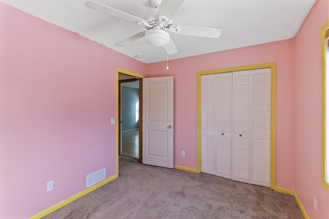 unfurnished bedroom featuring light colored carpet, a closet, visible vents, and baseboards