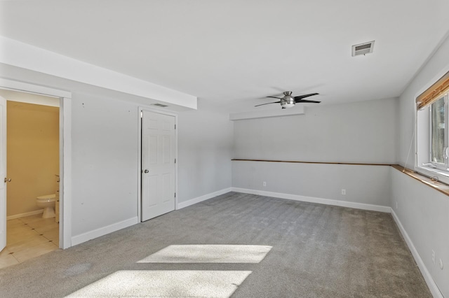 unfurnished room featuring a ceiling fan, visible vents, light carpet, and baseboards