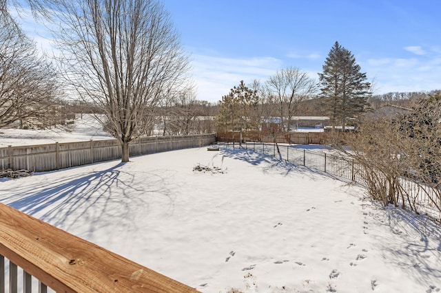 snowy yard featuring fence