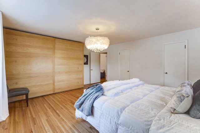 bedroom with hardwood / wood-style floors and a chandelier