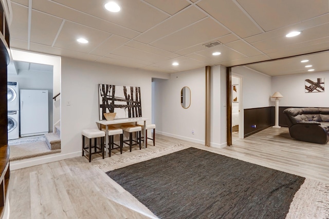 interior space with stacked washer / drying machine and wood-type flooring