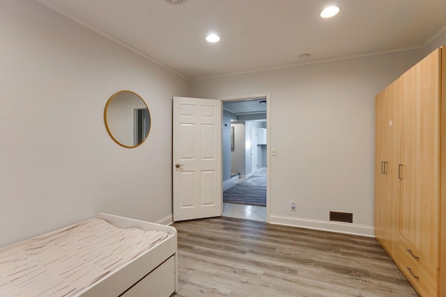 unfurnished bedroom with light wood-type flooring and crown molding