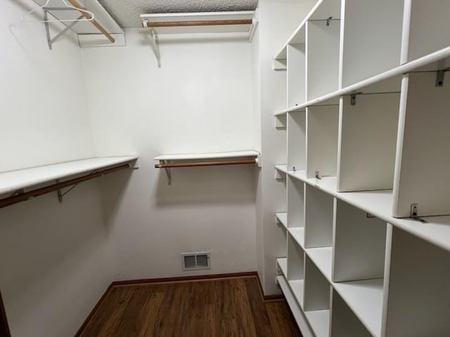 spacious closet featuring visible vents and wood finished floors