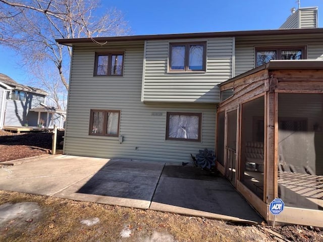 rear view of property featuring a patio area and a sunroom