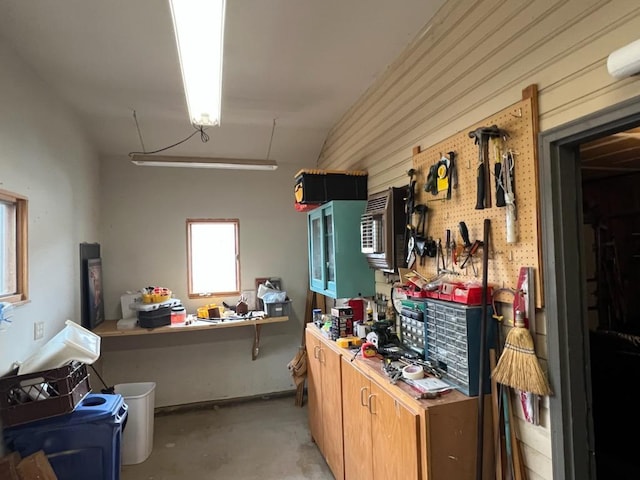 miscellaneous room with a workshop area and concrete floors