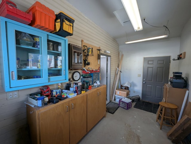 kitchen with wooden walls and concrete floors