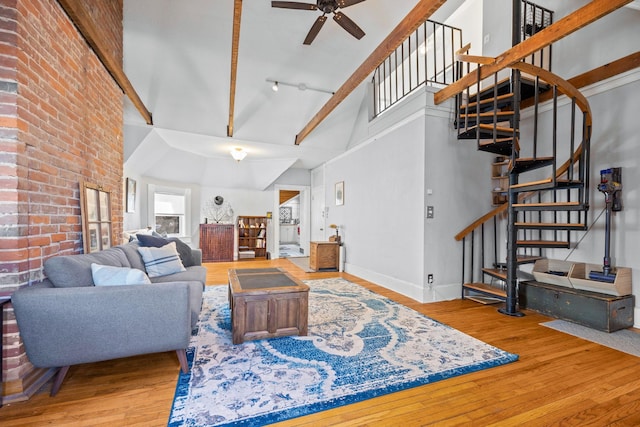 living room featuring ceiling fan, light hardwood / wood-style floors, and a high ceiling