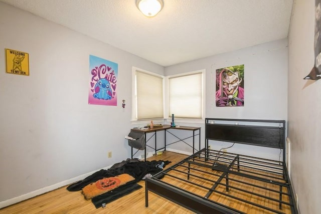 bedroom featuring wood-type flooring and a textured ceiling