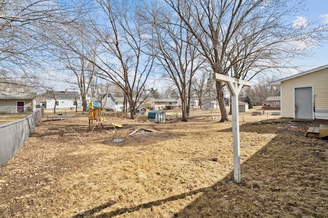 view of yard featuring a playground, fence, and a residential view