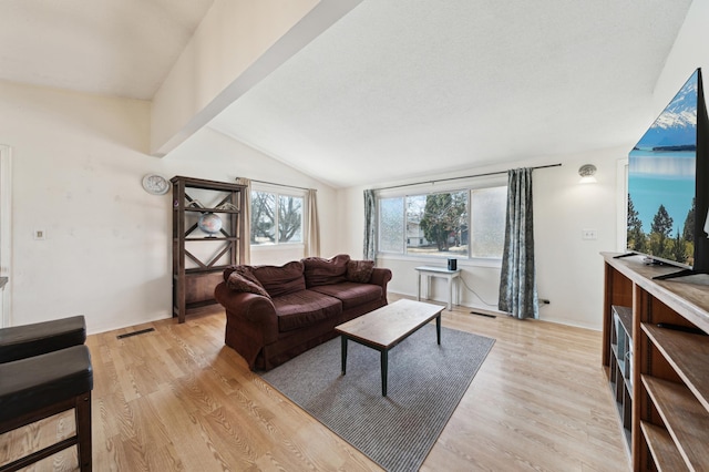 living area featuring light wood-type flooring, visible vents, and lofted ceiling