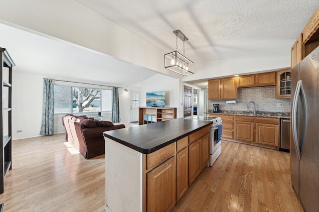 kitchen featuring vaulted ceiling, open floor plan, freestanding refrigerator, white range with electric cooktop, and dark countertops