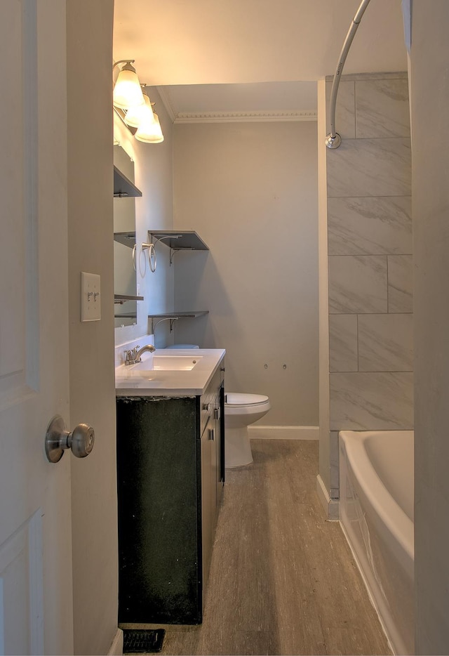 full bathroom with hardwood / wood-style flooring, vanity, ornamental molding, toilet, and tiled shower / bath