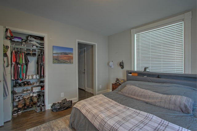 bedroom with dark hardwood / wood-style flooring and a closet