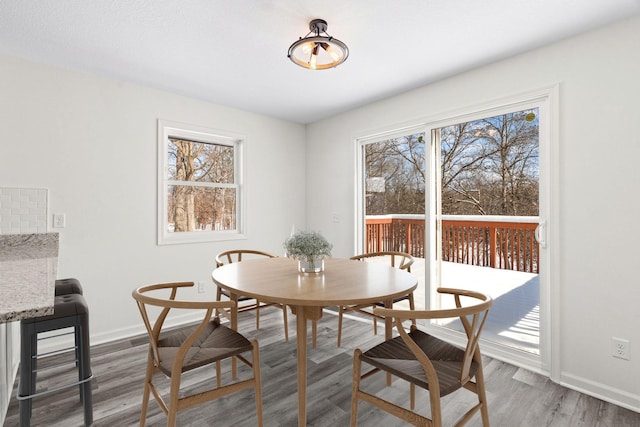 dining space with a healthy amount of sunlight, baseboards, and wood finished floors