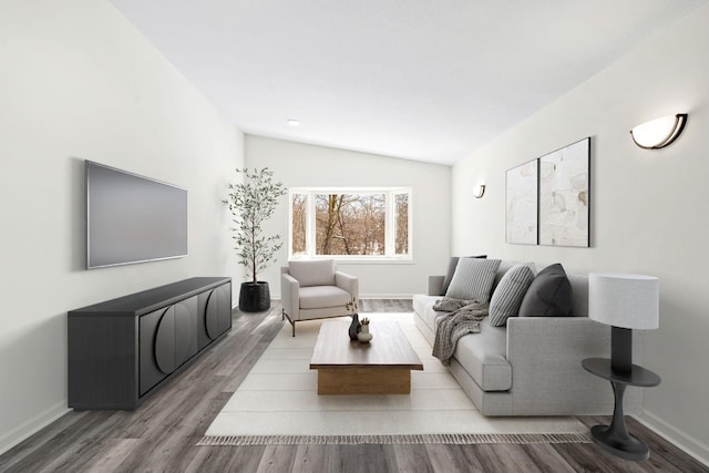 living area featuring baseboards, vaulted ceiling, and light wood finished floors