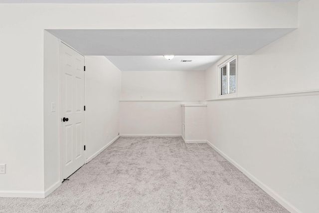 spare room featuring visible vents, baseboards, and light colored carpet