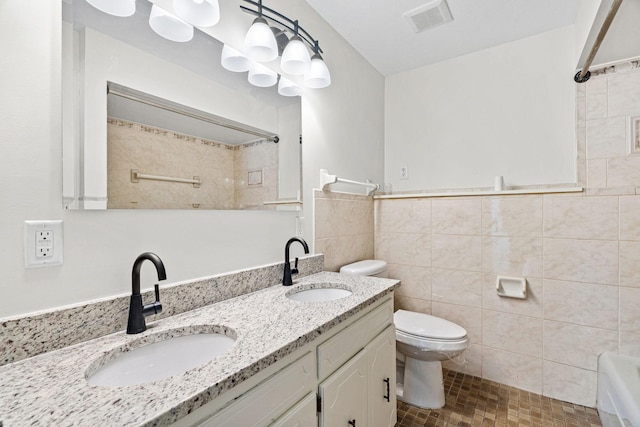 bathroom with toilet, tile walls, visible vents, and a sink