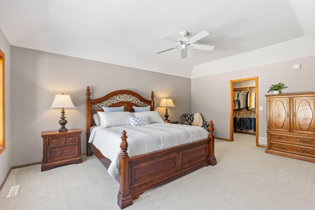 bedroom with light carpet, visible vents, baseboards, a closet, and a walk in closet