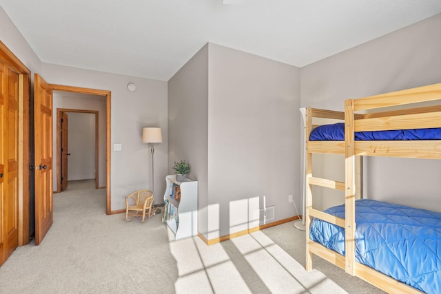 bedroom with baseboards and light colored carpet