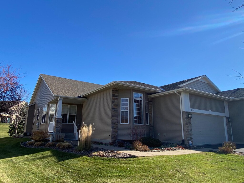 view of front of property featuring an attached garage and a front lawn