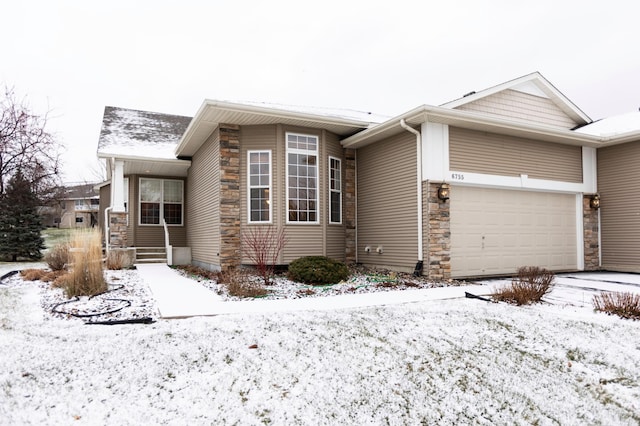 view of front of home with a garage and stone siding