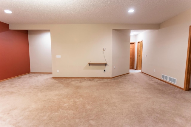 empty room featuring light carpet, baseboards, and visible vents