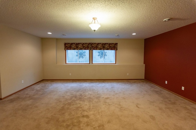 carpeted empty room featuring recessed lighting, a textured ceiling, and baseboards