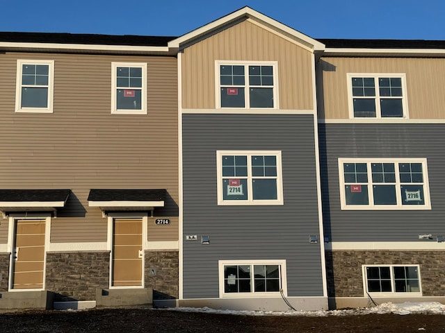 view of front of property featuring stone siding and board and batten siding