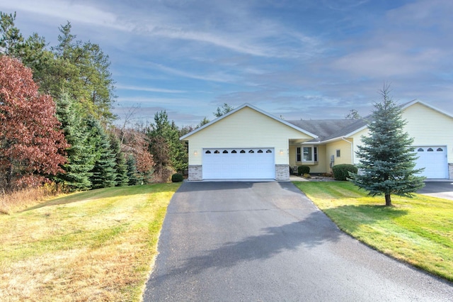 ranch-style house featuring a garage, stone siding, aphalt driveway, and a front yard