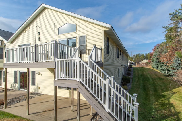 back of property with a yard, stairway, and a patio area