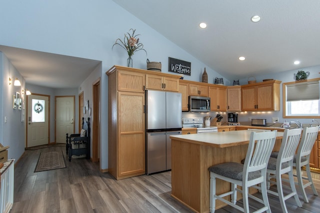 kitchen with a kitchen island, stainless steel appliances, light countertops, light wood-style floors, and recessed lighting