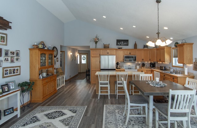 kitchen featuring dark wood-type flooring, light countertops, appliances with stainless steel finishes, a center island, and pendant lighting