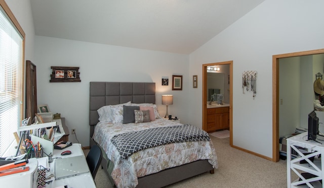 bedroom with lofted ceiling, multiple windows, ensuite bathroom, and light colored carpet